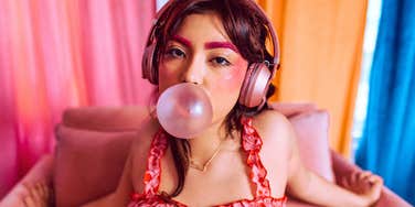 pretty woman on her couch chewing bubblegum