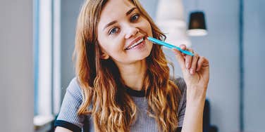 Smart woman holding pen working on new frugal habits to save money 