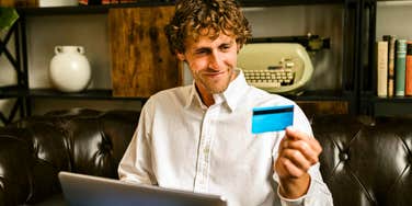 man paying his bills with credit card living within his means