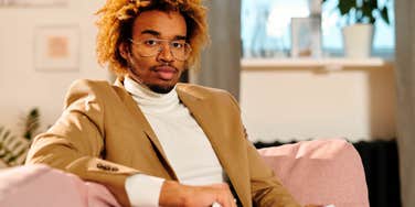 young gen Z professional man sitting on work couch