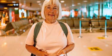 older woman holding her passport waiting in the airport