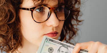 young woman holding money to invest