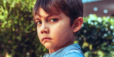 sad serious child who was raised by narcissistic parents