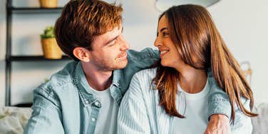 A man comforting his thoughtful wife in a warm living room, symbolizing empathy, marital stability, and emotional support.