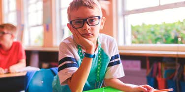 child looking bored in school classroom