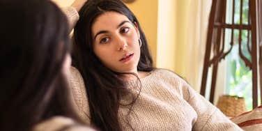 young woman whose parents had zero social skills talks uncomfortably to someone else