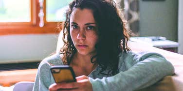 uninterested woman distracted by phone acting like she can't hear
