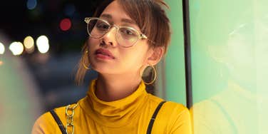 resentful young woman standing outside alone