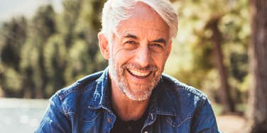 A senior man resting outdoors near a lake on a sunny afternoon, symbolizing peace of mind, financial independence, and lifestyle freedom.