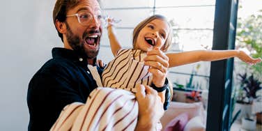 dad with a good sense of humor being silly with his daughter