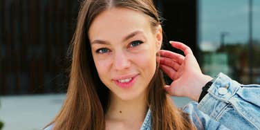 People Who Actually Respect Themselves Usually Say Phrases Instead Of 'It's OK' A poised woman smiling warmly in a modern setting, symbolizing emotional maturity, self-respect, and clear communication boundaries.