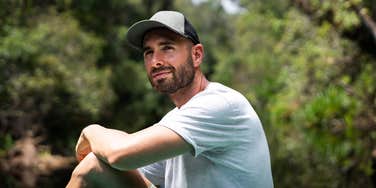 Man who needs alone time to recharge sits alone outdoors