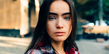 Woman who pretends to be cool but she's not looks moody 