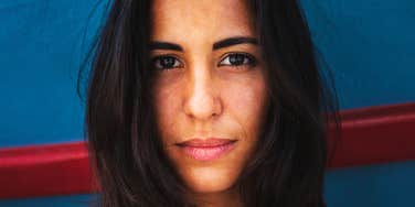 A young Latina woman with dark hair staring with a focused and serious expression, symbolizing self-respect, strong boundaries, and personal authority.