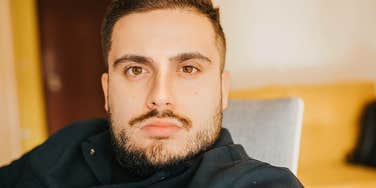 Man who is boring looks blandly at the camera 