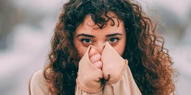 nervous insecure woman covering her face