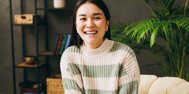 Woman who rarely feels overwhelmed smiles in her cozy home