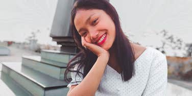 woman who is a loner smiling by herself outside