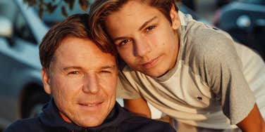 devoted father sitting with his teen son