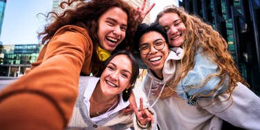 group of gen z and millennials taking a carefree selfie