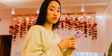 impatient gen z young woman looking up from phone