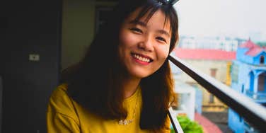friendly smiling woman standing on a balcony