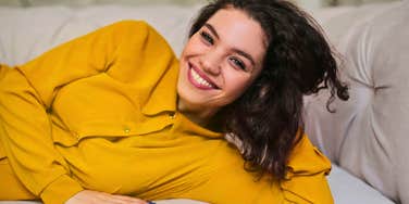 stress free woman at home on her couch smiling