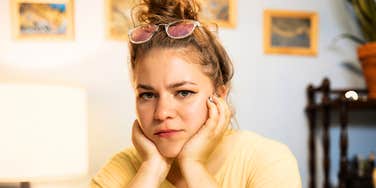 A woman making an annoyed gesture at desk, symbolizing daily frustration, emotional dysregulation, and communication friction.