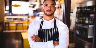 annoyed restaurant waiter with his arms crossed