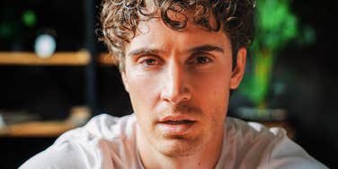 Man's intense, close-up gaze reflects the pressure behind a booming industry built on male insecurity.