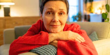 Woman rests her chin on crossed arms, her easy smile reflecting the calm confidence of setting a boundary.