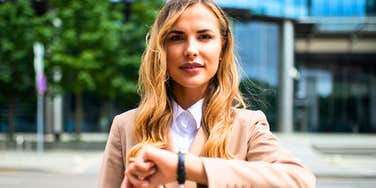 woman checking her watch arriving early to event
