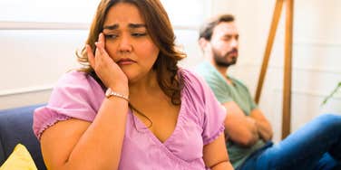 woman crying turned away from husband she loves too much