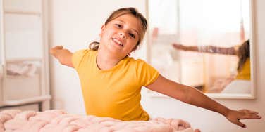 young girl playing by herself in her pink bedroom