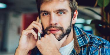 Young man smiling on the phone with his parents