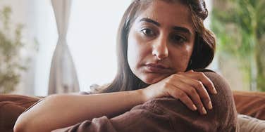 Young woman raised by emotionally flaky parents looks sad in a room alone