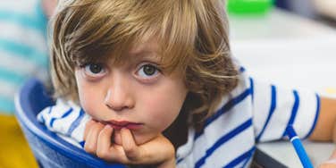 quiet child looking nervous in a blue chair