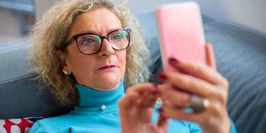 boomer woman looking at her phone seeming annoyed