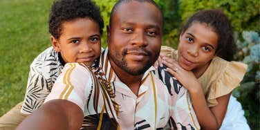 father taking selfie with kids raising them to be emotionally intelligent