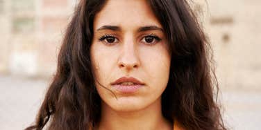 Woman's direct, unguarded stare captures the quiet weight of words that hurt despite good intentions.
