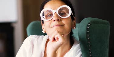 Confident woman rests her chin on her hand, the composed resolve of someone who doesn't quit when others do.