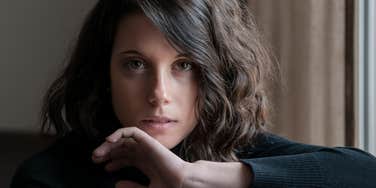 young woman who feels super hold looks at camera in serious way