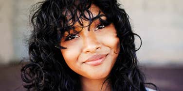 Woman's soft, genuine smile reflects the quiet resilience of someone who's healed and moved forward.