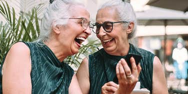 Two older women who are mentally bright chatting casually and laughing