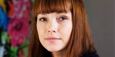 Woman with a calm, measured expression reflects the emotional control behind choosing words carefully.