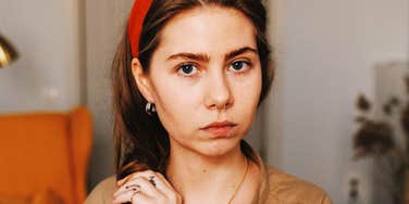 Woman's wary, unflinching stare reflects the guardedness of growing up around manipulative words.