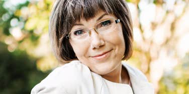 Her wry, knowing smile over the glasses hints at judgments she's not hiding as well as she thinks.