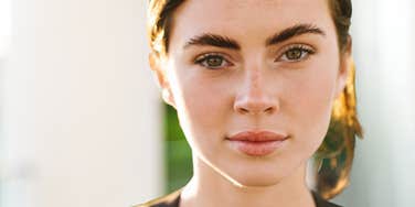 Sneaky-looking woman lacks moral integrity and stares into camera menacingly 