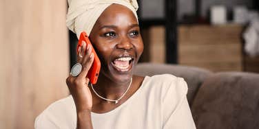 woman who is good at keeping secrets excited talking on the phone