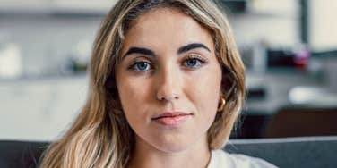 Woman who is losing her ability to forgive with a wry smile 